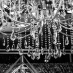 A stunning black and white image of a luxurious crystal chandelier with intricate design details.