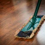 A detailed view of a mop cleaning a wooden floor, showing texture and pattern.